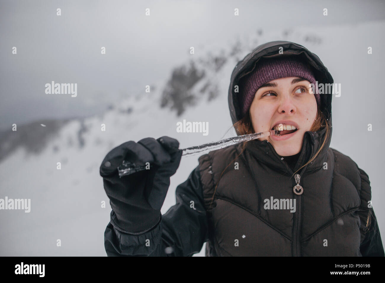 Österreich, Kitzbühel, Porträt der jungen Frau beißen icicle Stockfoto