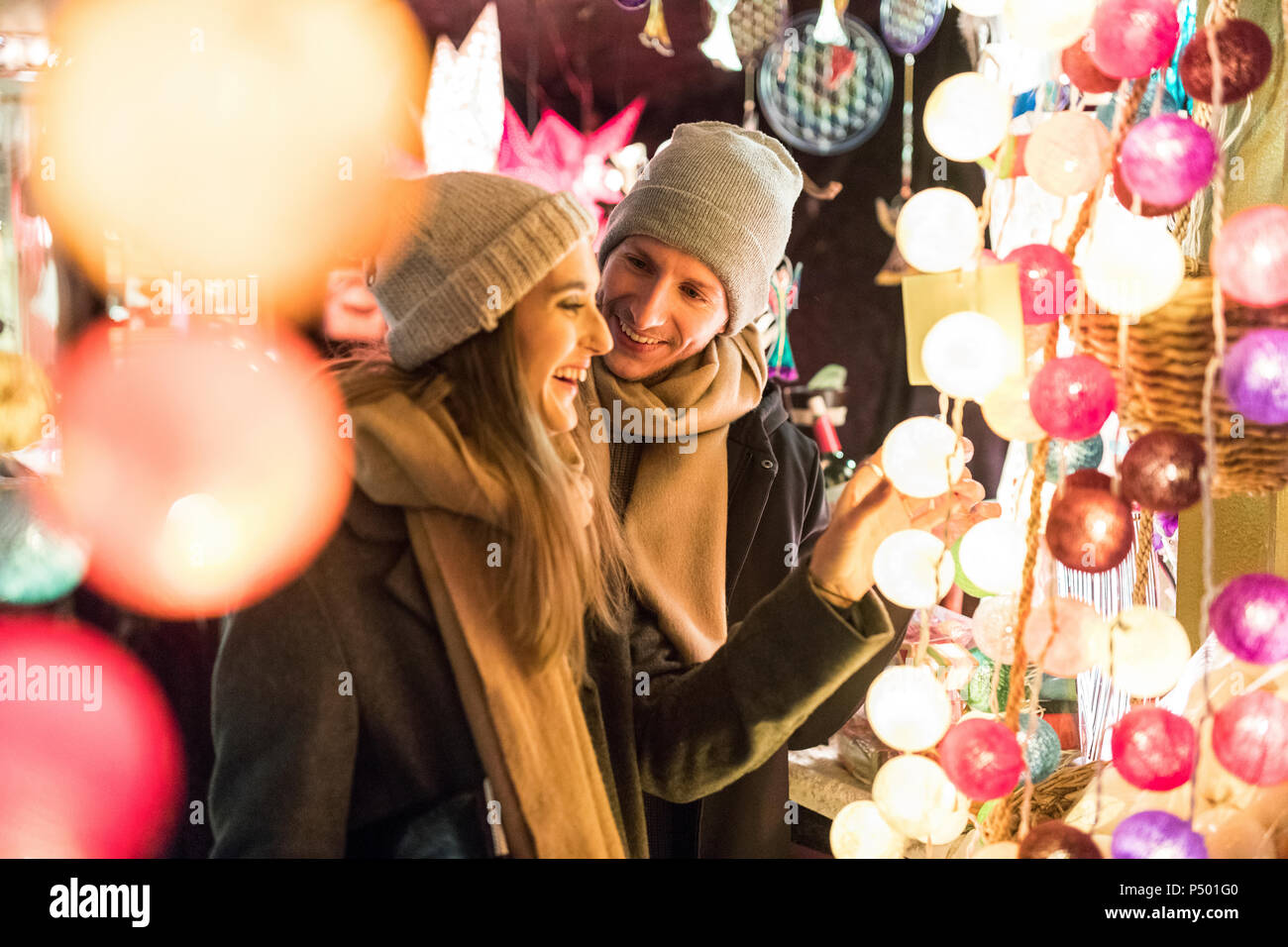 Junges Paar beobachten Angebot an Weihnachtsmarkt Stockfoto