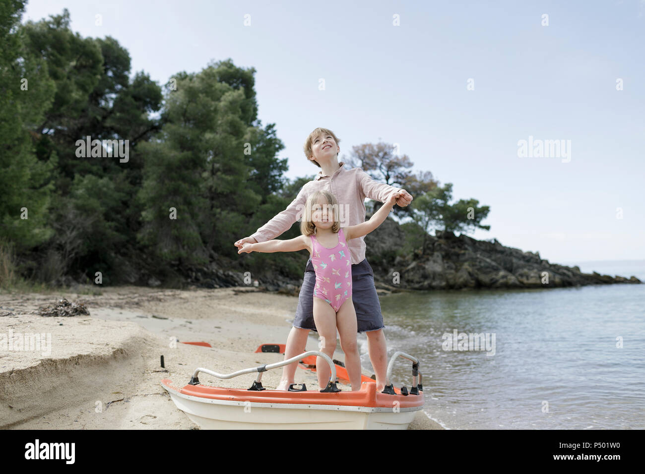 Bruder und kleine Schwester spielen zusammen am Strand Stockfoto