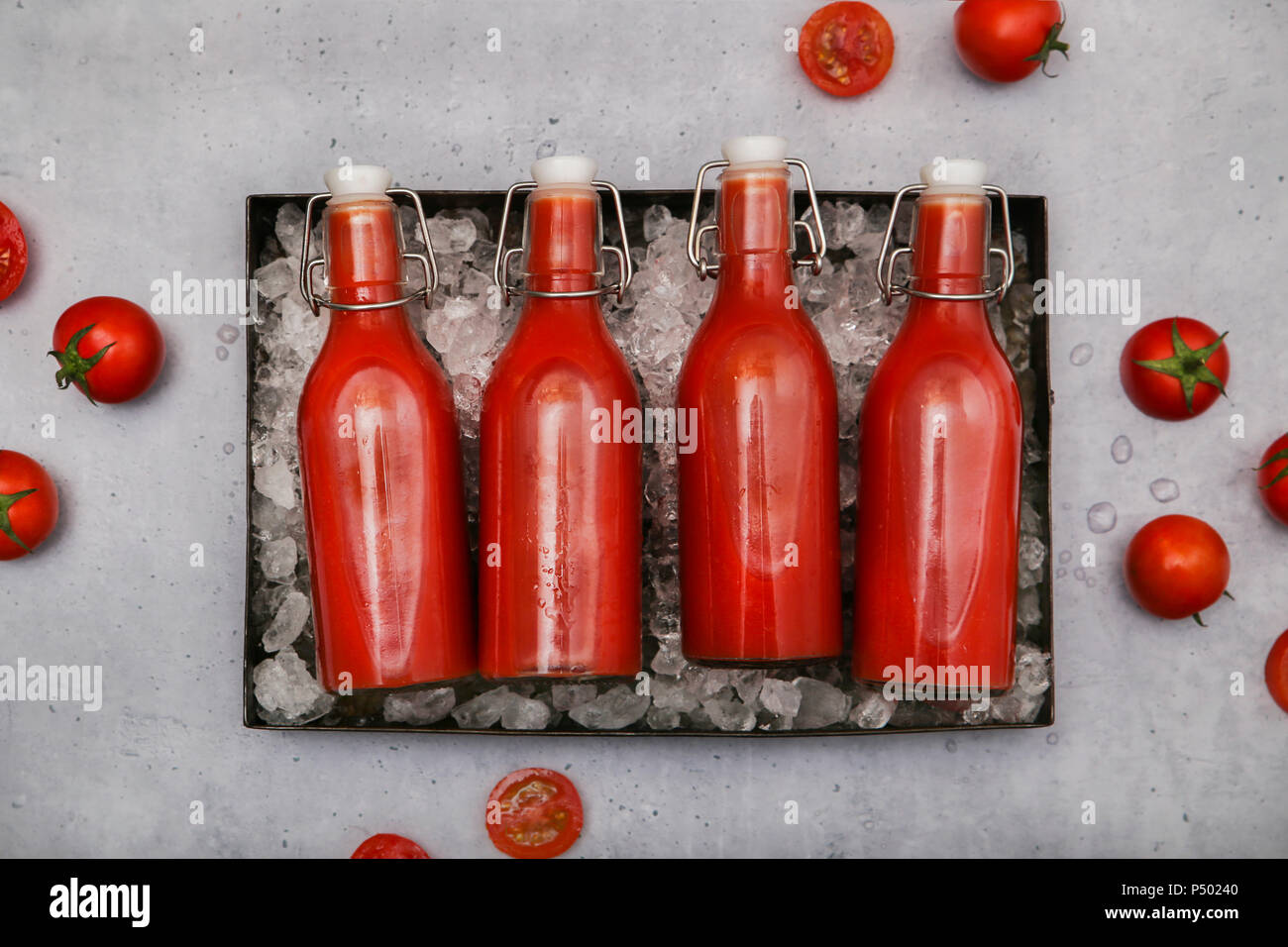 Zeile vier ice-gekühlte Bügelverschlussflaschen mit hausgemachten Tomatensaft Stockfoto