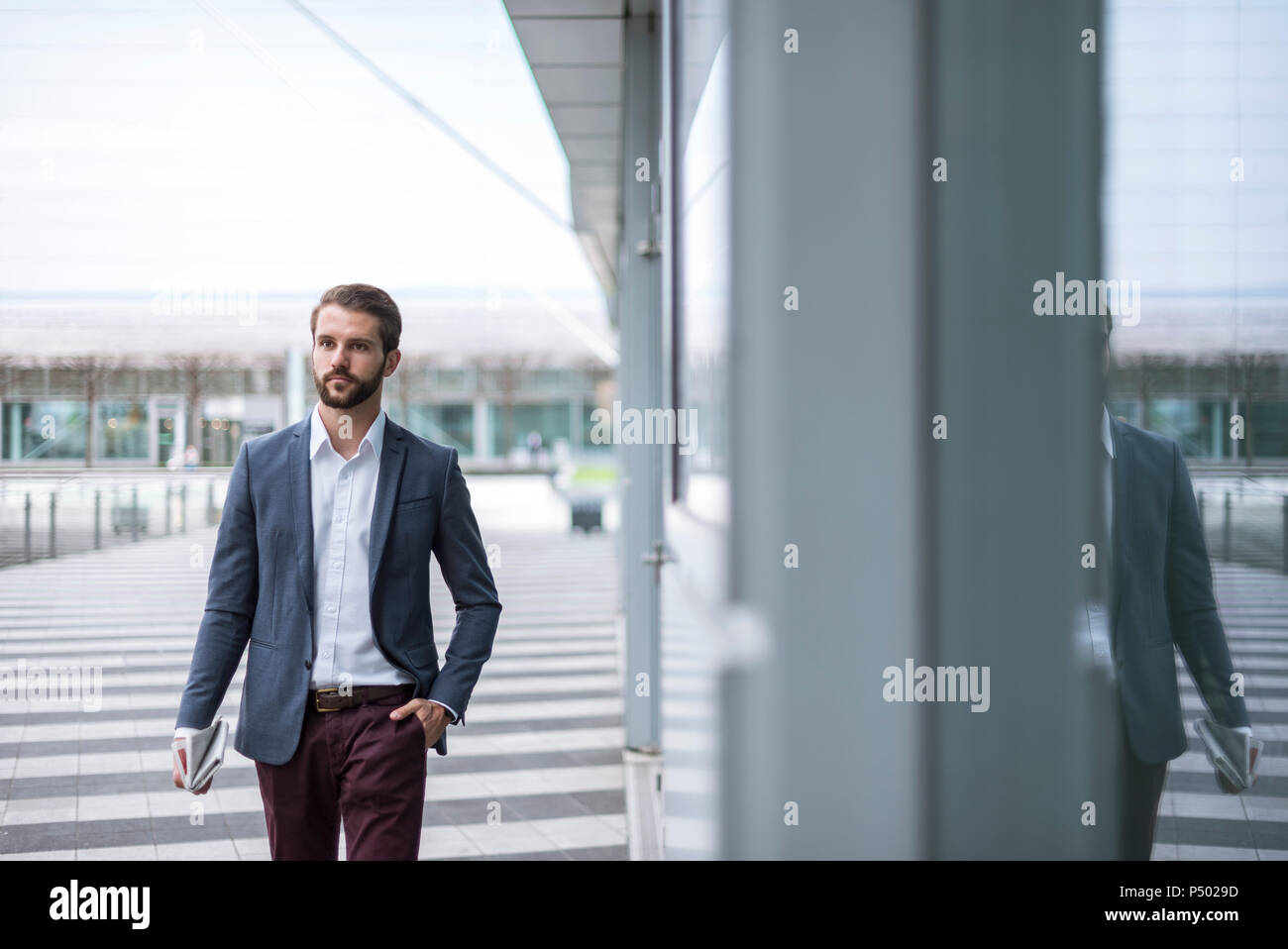 Junge Unternehmer unterwegs am Gebäude mit Glasfassade. Stockfoto