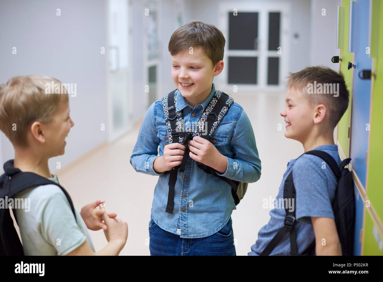 Glückliche Schüler reden Schließfächer in der Schule Stockfoto