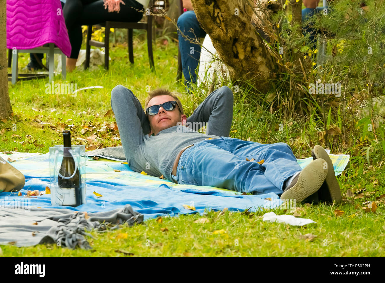 Johannesburg, Südafrika, 05.09.2015, jungen Mann auf einer Picknickdecke auf der Winter-Skulptur Messe am Nirox Sculpture Park Stockfoto Johannesburg, Südafrika, 05.09.2015, jungen Mann auf einer Picknickdecke auf der Winter-Skulptur Messe am Nirox Sculpture Park Stockfoto