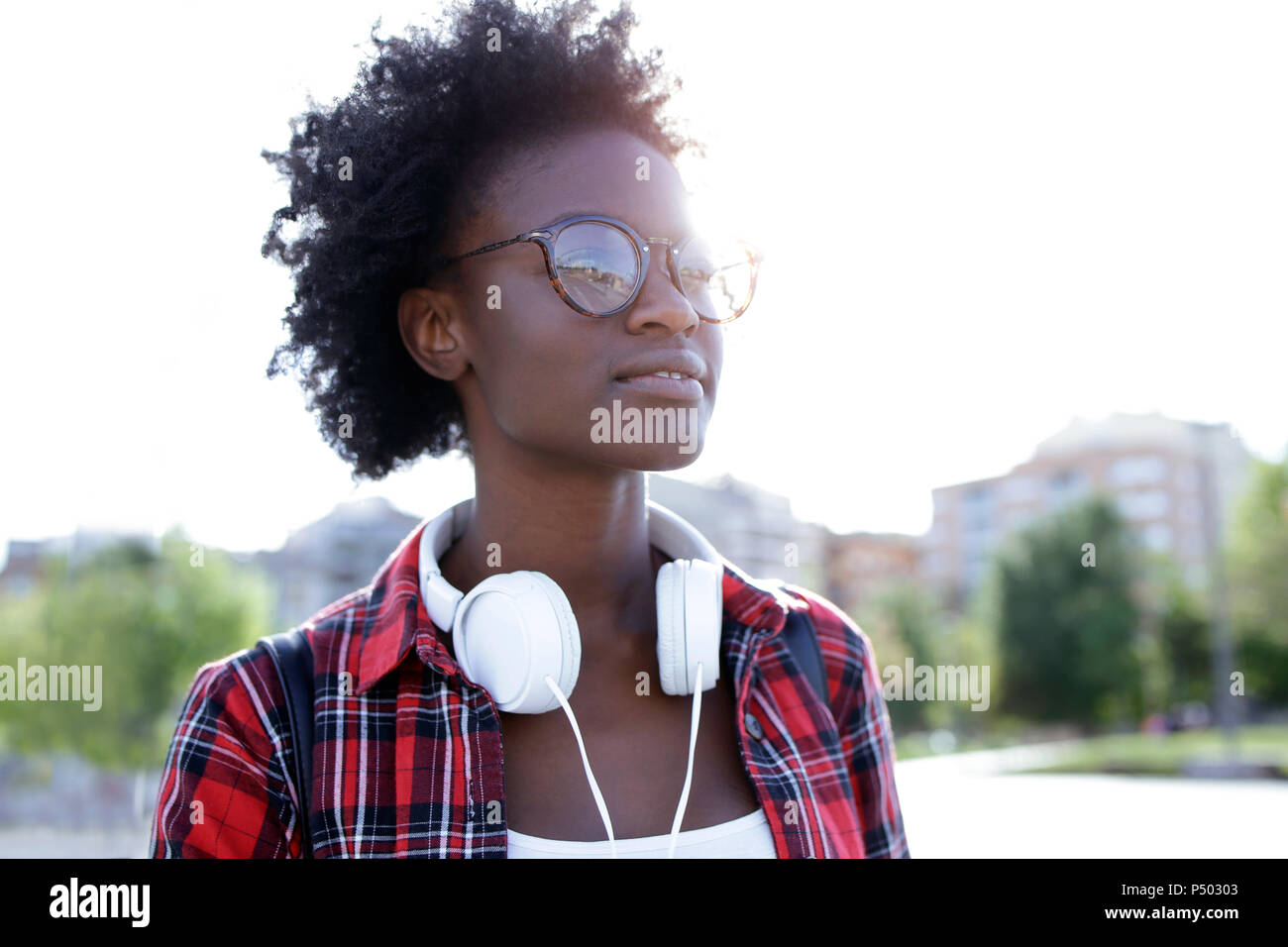 Porträt der jungen Frau mit Kopfhörern mit Hintergrundbeleuchtung Stockfoto
