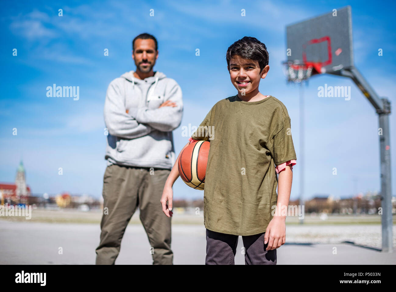 Porträt der jungen mit Vater am Basketballplatz im Freien Stockfoto