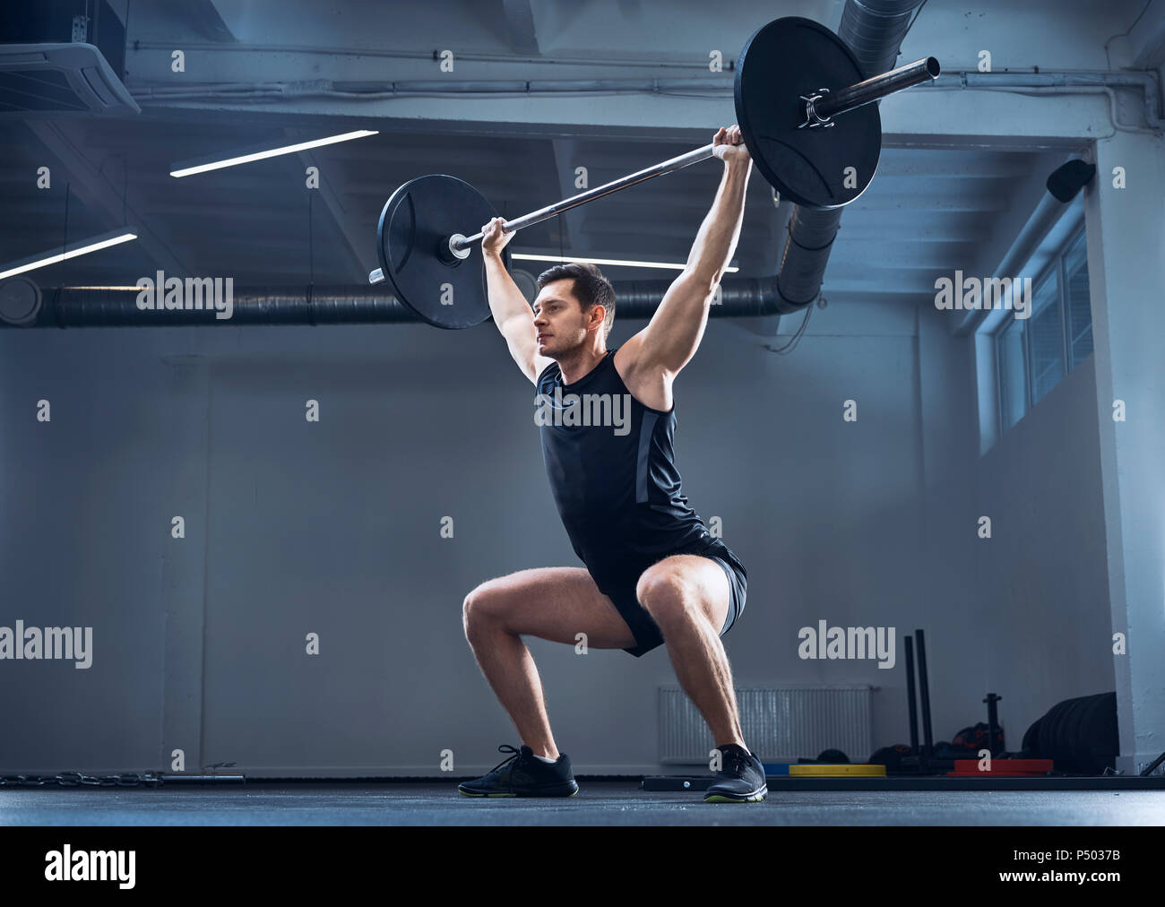 Mann tun Hantel Training im Fitnessraum während Gewichtheben Workout Stockfoto