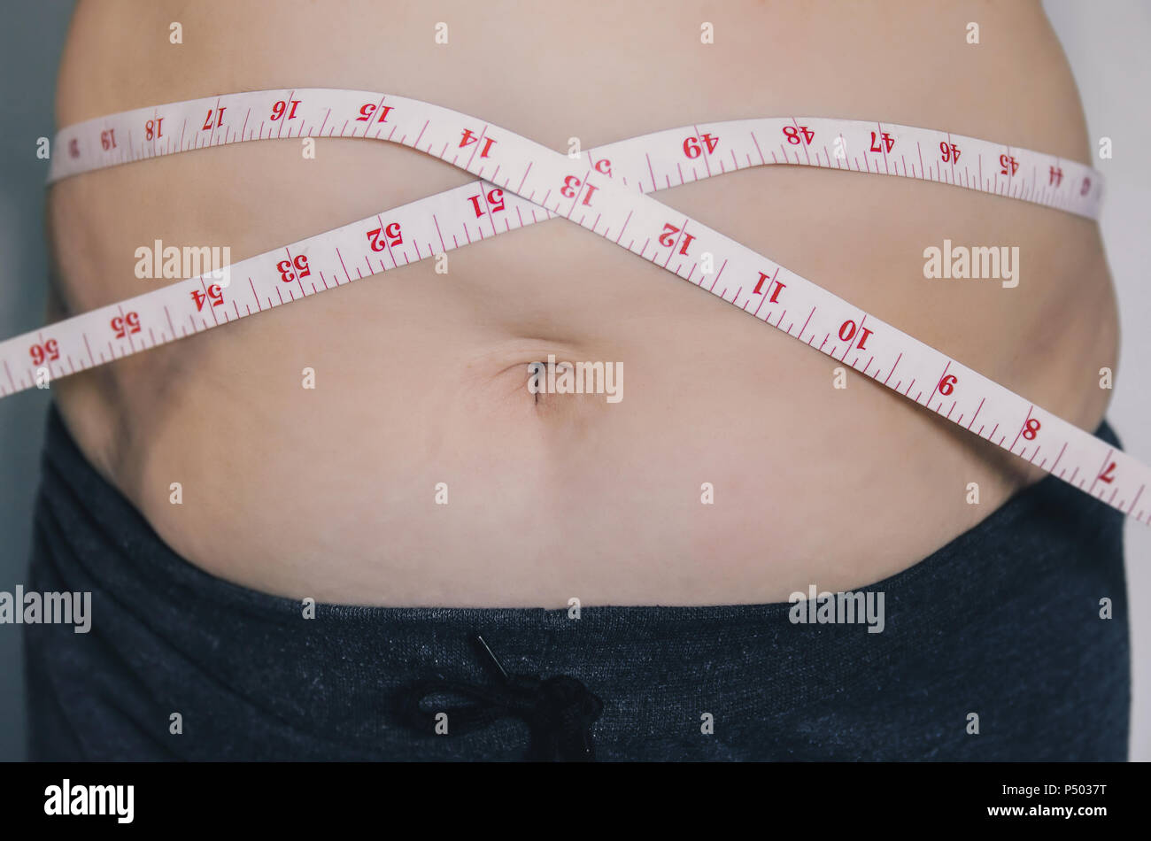 Nahaufnahme des menschlichen Körpers und fetten Körper, Fett Körper Teil der Bauch oder Bauch, Übergewicht von Personen oder Übergewicht mit Maßband. Stockfoto