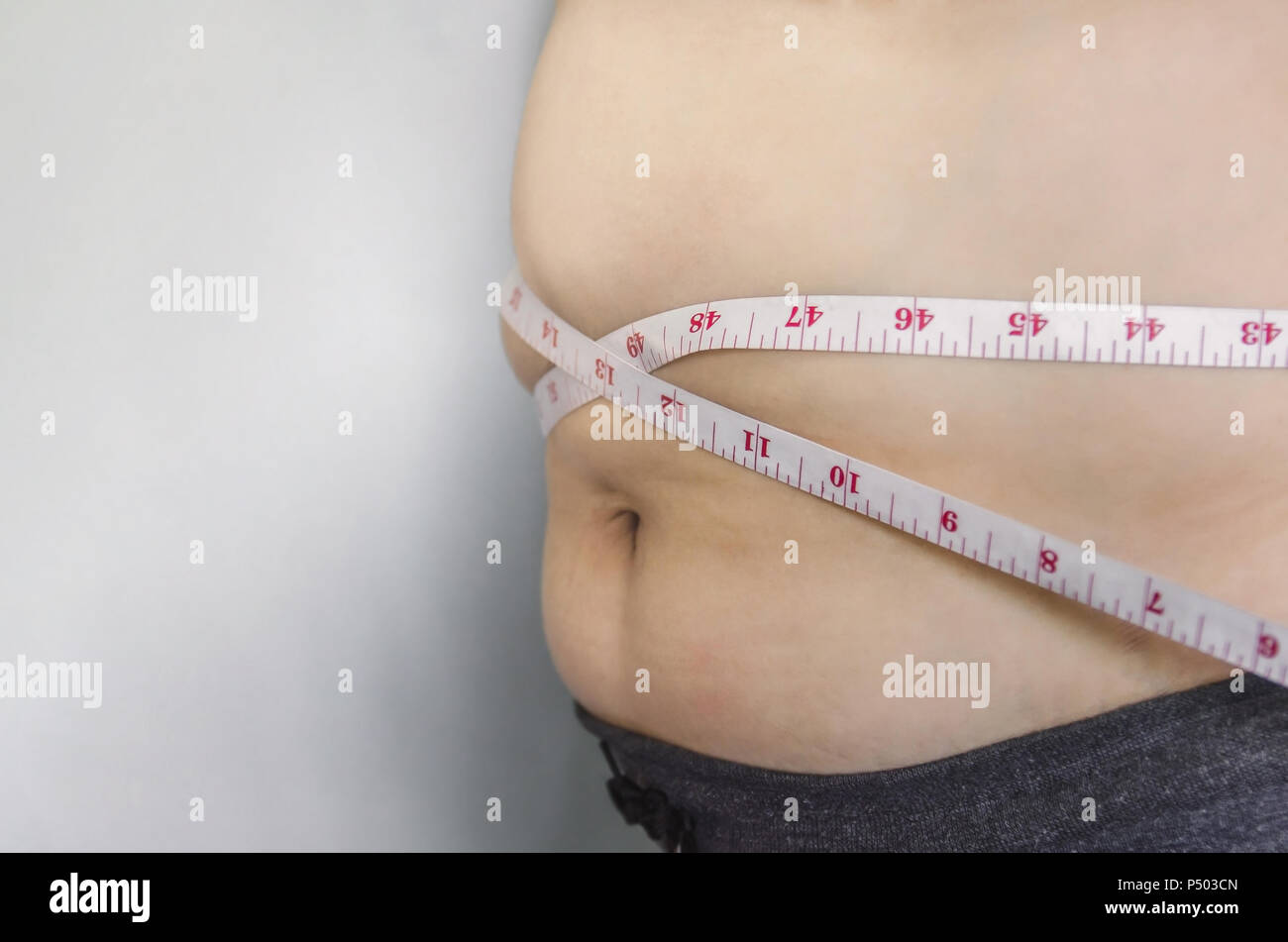 Nahaufnahme des menschlichen Körpers und fetten Körper, Fett Körper Teil der Bauch oder Bauch, Übergewicht von Personen oder Übergewicht mit Maßband. Stockfoto