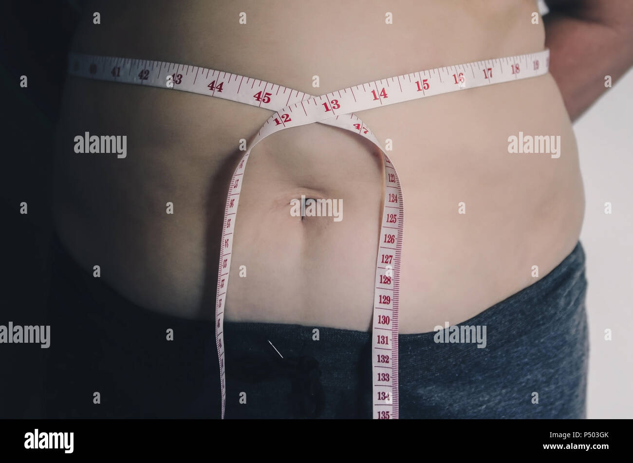 Nahaufnahme des menschlichen Körpers und fetten Körper, Fett Körper Teil der Bauch oder Bauch, Übergewicht von Personen oder Übergewicht mit Maßband. Stockfoto