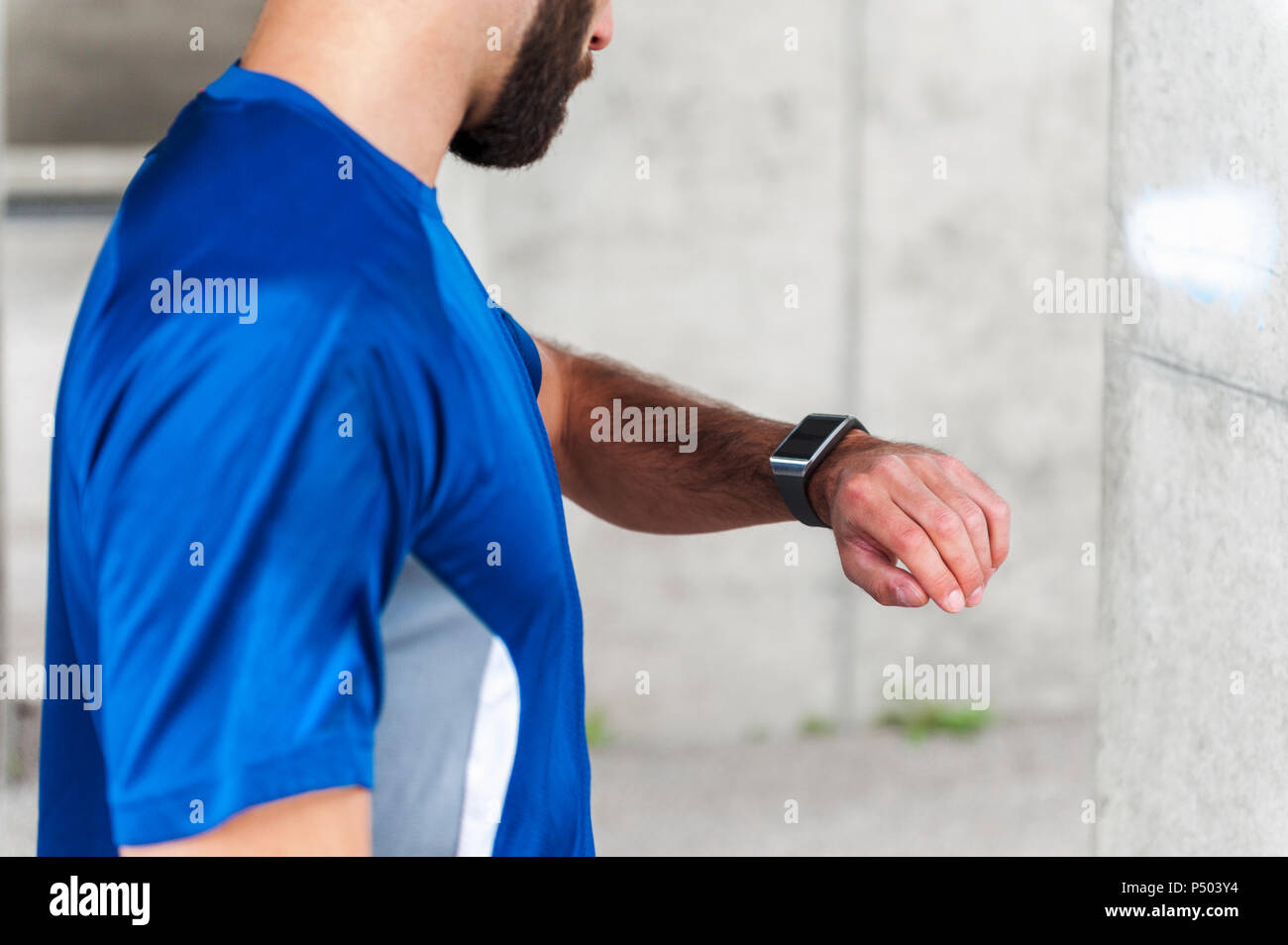 Mensch, der hatte eine Pause von der laufenden Kontrolle der Zeit auf einem smartwatch Stockfoto