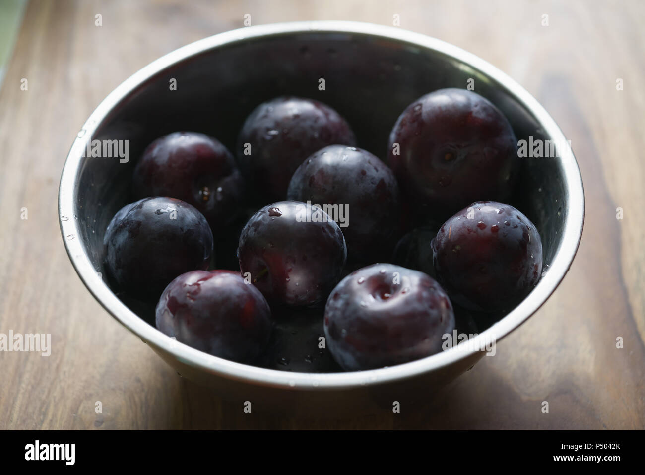 Frisch große Pflaumen in einer Schale auf Holz Tisch gewaschen, flachen Fokus Stockfoto