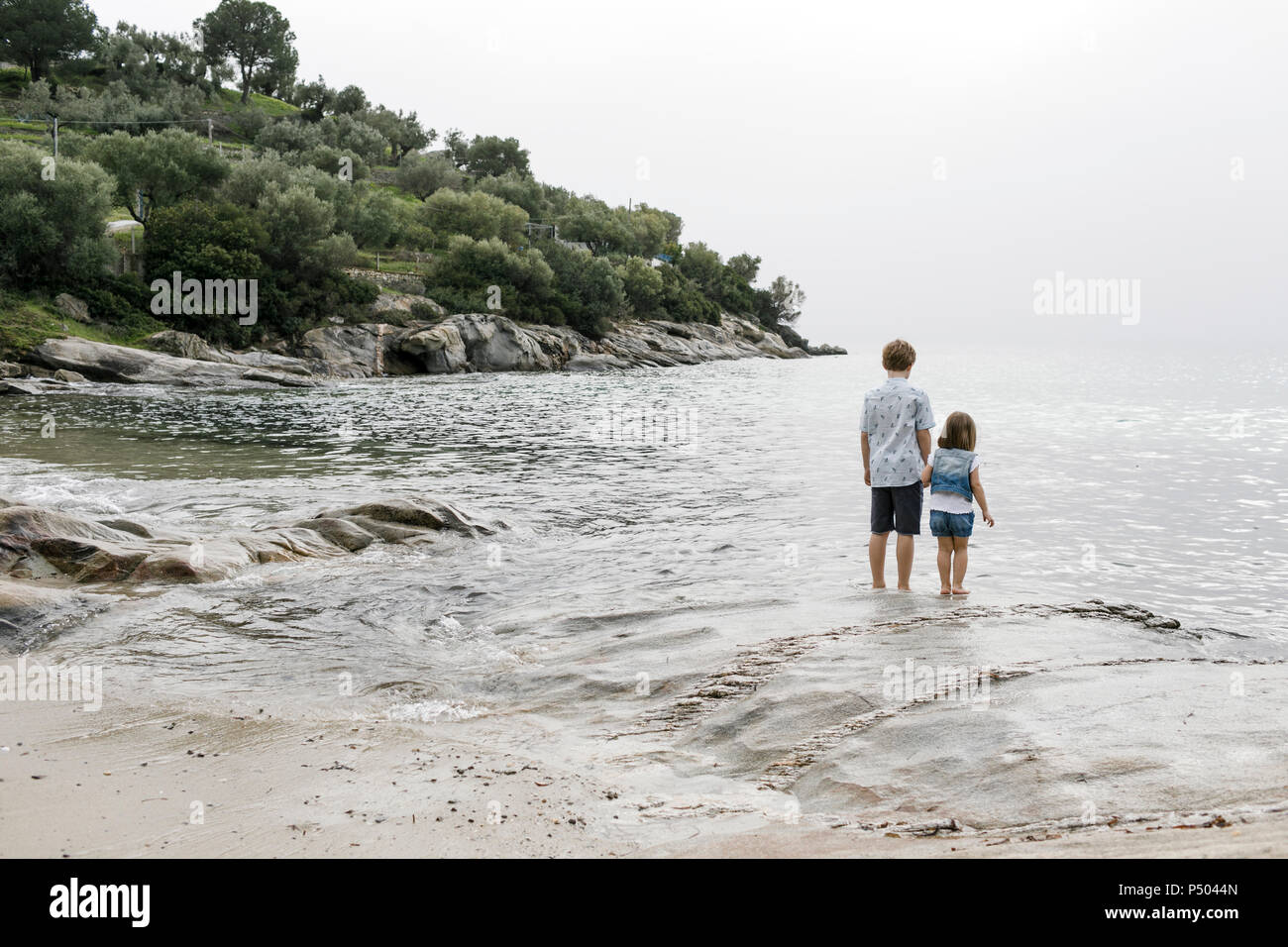 Griechenland, Chalkidiki, Rückansicht von Bruder und kleine Schwester am Meer Stockfoto