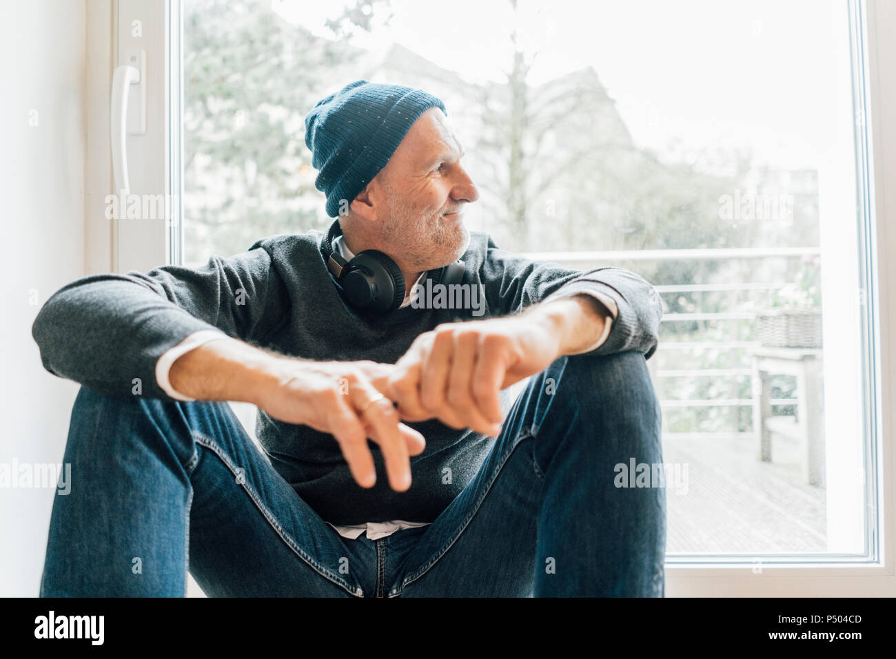 Cool älterer Mann sitzt auf Longboard, schauen aus dem Fenster Stockfoto