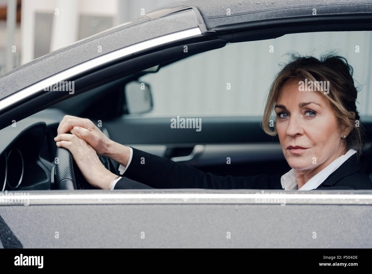 Portrait von zuversichtlich senior Geschäftsfrau im Auto. Stockfoto