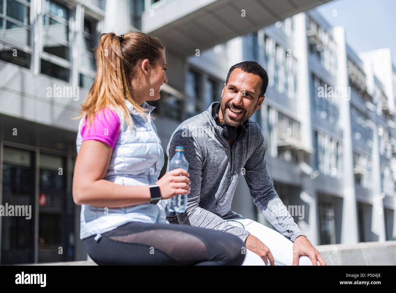 Aktive Paare mit Wasserflasche mit einer Unterbrechung in der Stadt Stockfoto