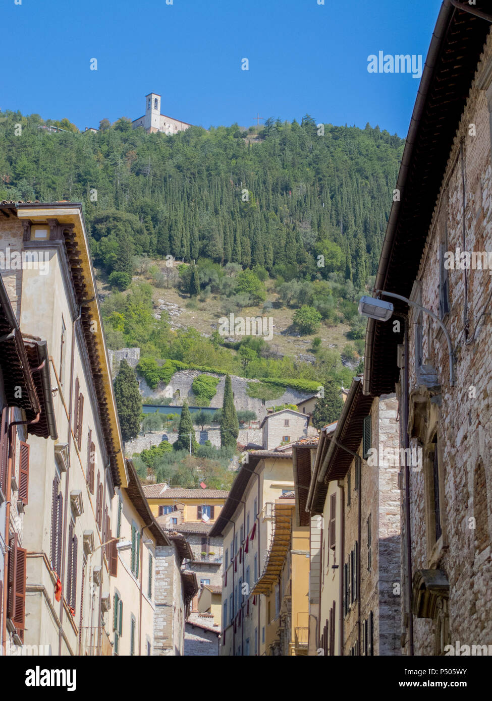 Charakteristische Gasse in der mittelalterlichen Stadt Gubbio (Italien), mit den Bergen im Hintergrund. Stockfoto
