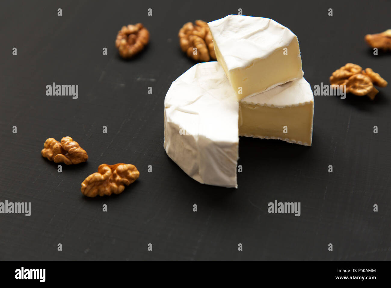 Käse, Camembert oder Brie mit Walnüssen auf dunklem Hintergrund. Die ...