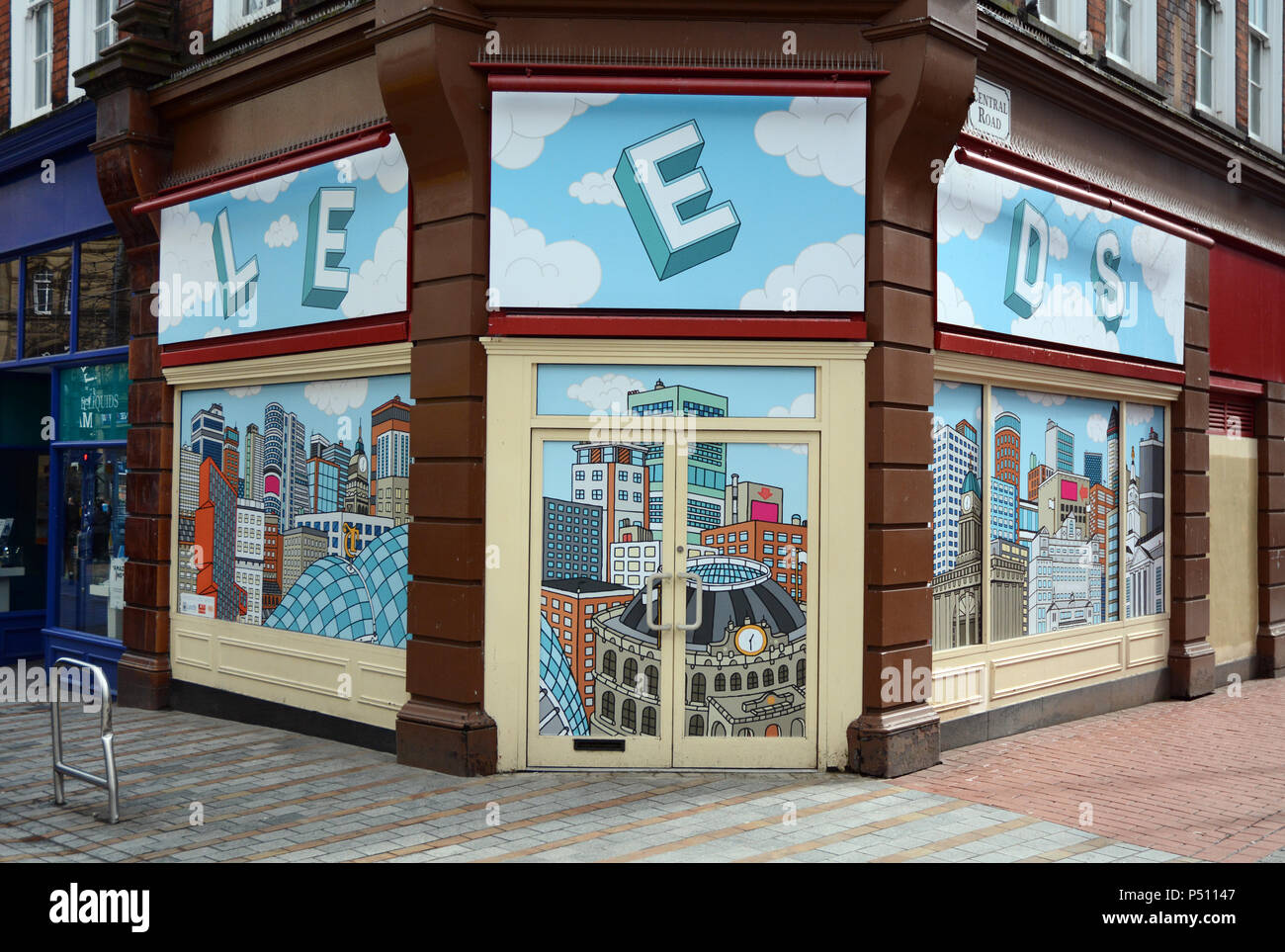 Eine leere storefront Ecke mit einem Hintergrundbild Abbildung der Stadt Leeds, in der Fußgängerzone in Leeds, England, Vereinigtes Königreich. Stockfoto