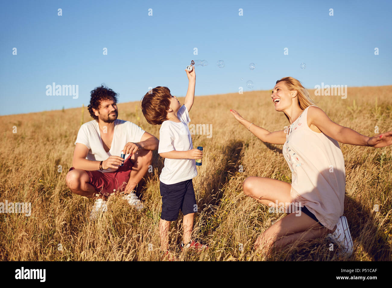 Die Familie spielt mit Seifenblasen in der Natur Stockfoto