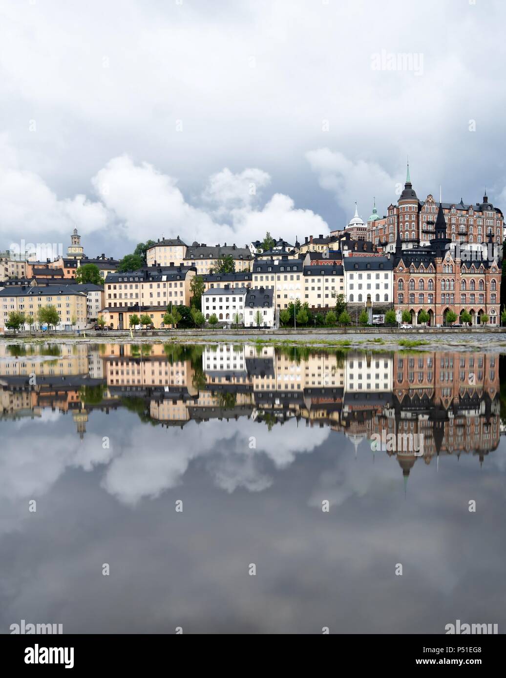 Einen abendlichen Spaziergang im Regen, nur liebte die Moody Wolken und Gebäude in der Pfütze in Stockholm, Schweden widerspiegelt. Juni, 2018. Stockfoto