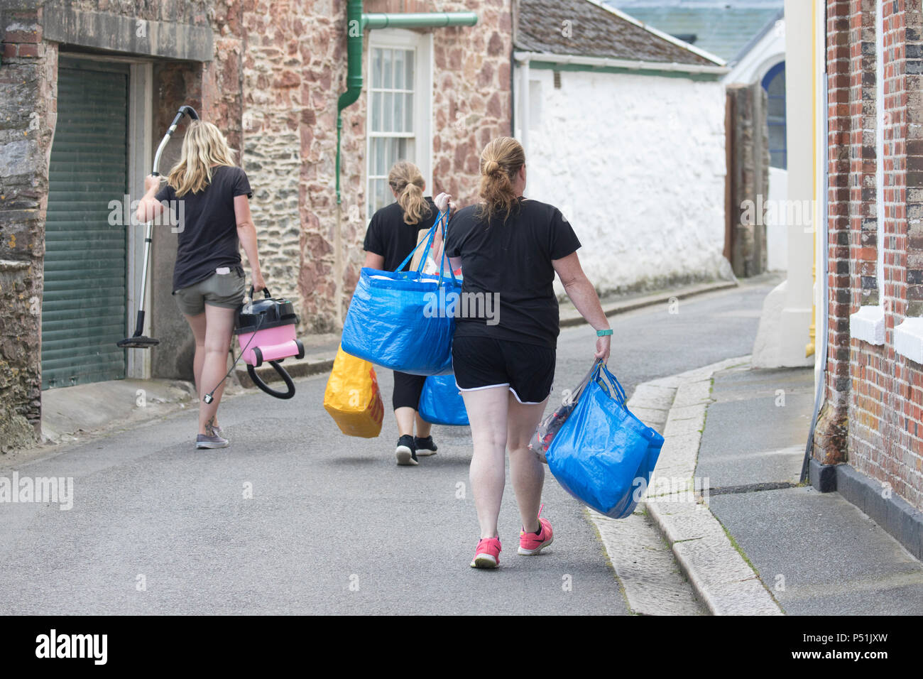 Das Housekeeping Zimmermädchen entlang einer schmalen Cornish Lane zwischen Kingsand und Cawsand auf ihre Umläufe von Reinigung Gast Hotels, self catering Häuser Stockfoto