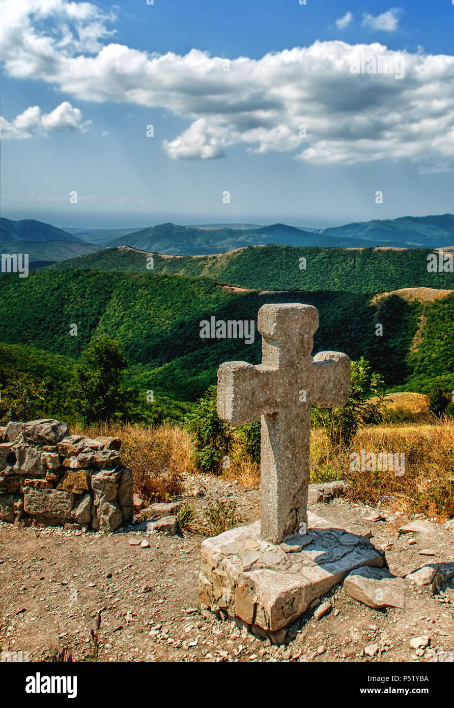Steinkreuz im Kaukasus. Panoramablick auf die Berge. Stockfoto Steinkreuz im Kaukasus. Panoramablick auf die Berge. Stockfoto