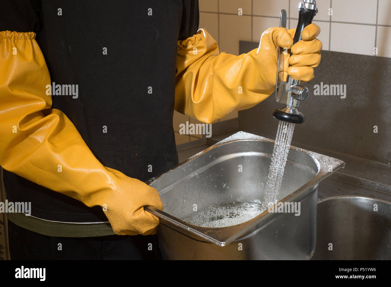 Reinigen von Edelstahl Behälter in einer großen Küche Stockfoto