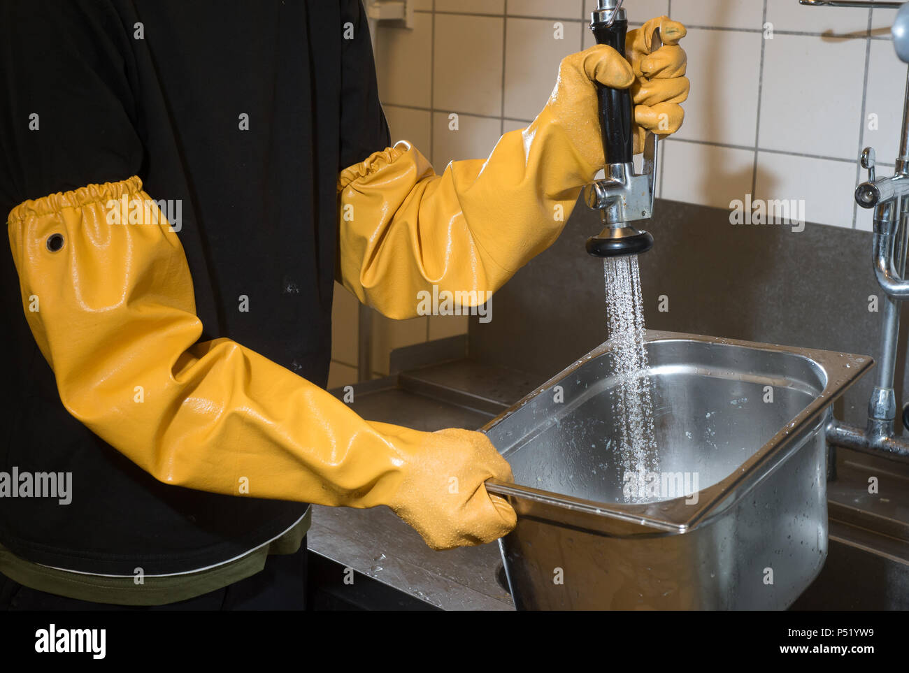 Reinigen von Edelstahl Behälter in einer großen Küche Stockfoto