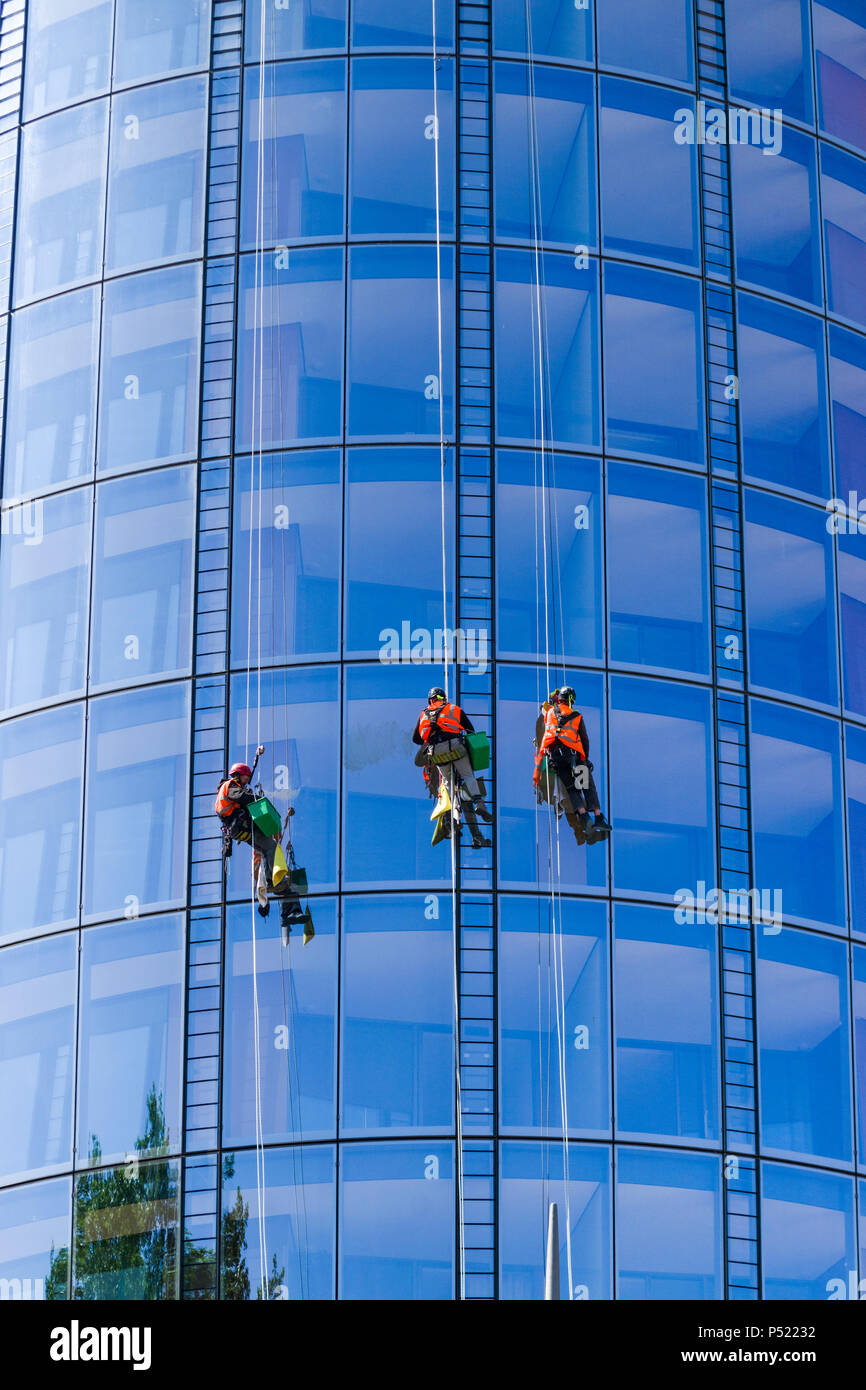 Fensterputzer, die das Äußere eines Blackfriars-Gebäudes abseilen, um die gesamte Glaskonstruktion zu inspizieren, London, Großbritannien Stockfoto