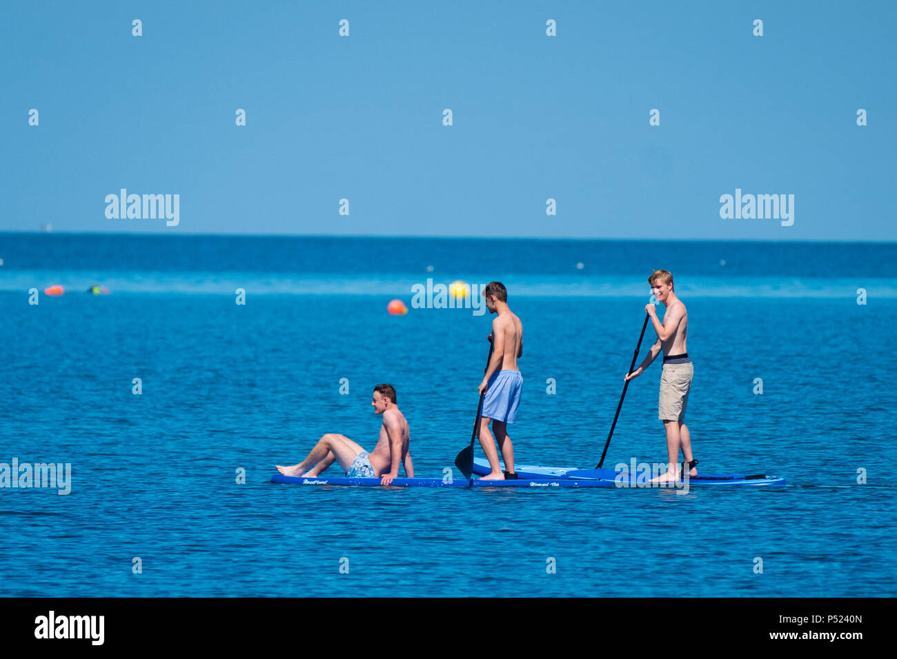 24. Juni 2018. Aberystwyth Wales UK UK Wetter: Junge Männer Paddle Boarding am Sonntag Morgen auf dem ruhigen Wasser der Cardigan Bay in Aberystwyth auf einem hellen und sonnigen Tag, wie die BRITISCHE Köpfe in ein mini Hitzewelle mit Temperaturen um 29° oder 30° Celsius bis Mitte der Woche Foto © Keith Morris Credit Hit: Keith Morris/Alamy leben Nachrichten Stockfoto
