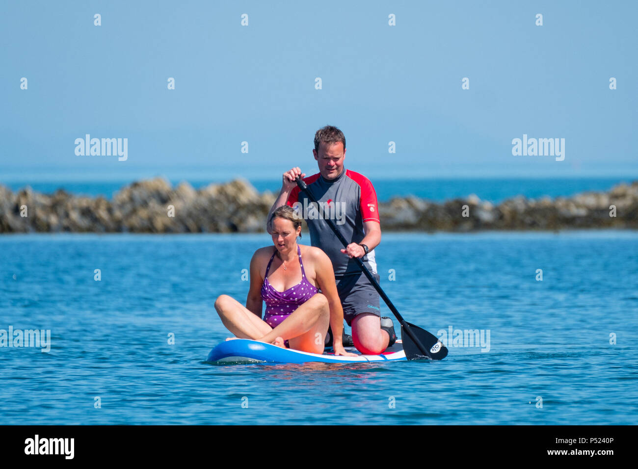 24. Juni 2018. Aberystwyth Wales UK UK Wetter: Ein paar Paddle Boarding am Sonntag Morgen auf dem ruhigen Wasser der Cardigan Bay in Aberystwyth auf einem hellen und sonnigen Tag, wie die BRITISCHE Köpfe in ein mini Hitzewelle mit Temperaturen um 29° oder 30° Celsius bis Mitte der Woche Foto © Keith Morris Credit Hit: Keith Morris/Alamy leben Nachrichten Stockfoto