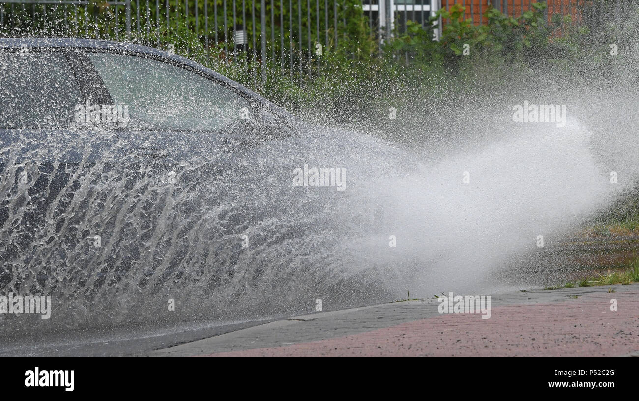 Stralsund, Deutschland. 21 Juni, 2018. Ein Auto fahren durch eine große Pfütze auf einer Straße in der Pomerania-Ruegen Rural District. Straßen in Mecklenburg-vorpommern sind teilweise unter Wasser nach starkem Regen. Quelle: Stefan Sauer/dpa-Zentralbild/dpa/Alamy leben Nachrichten Stockfoto