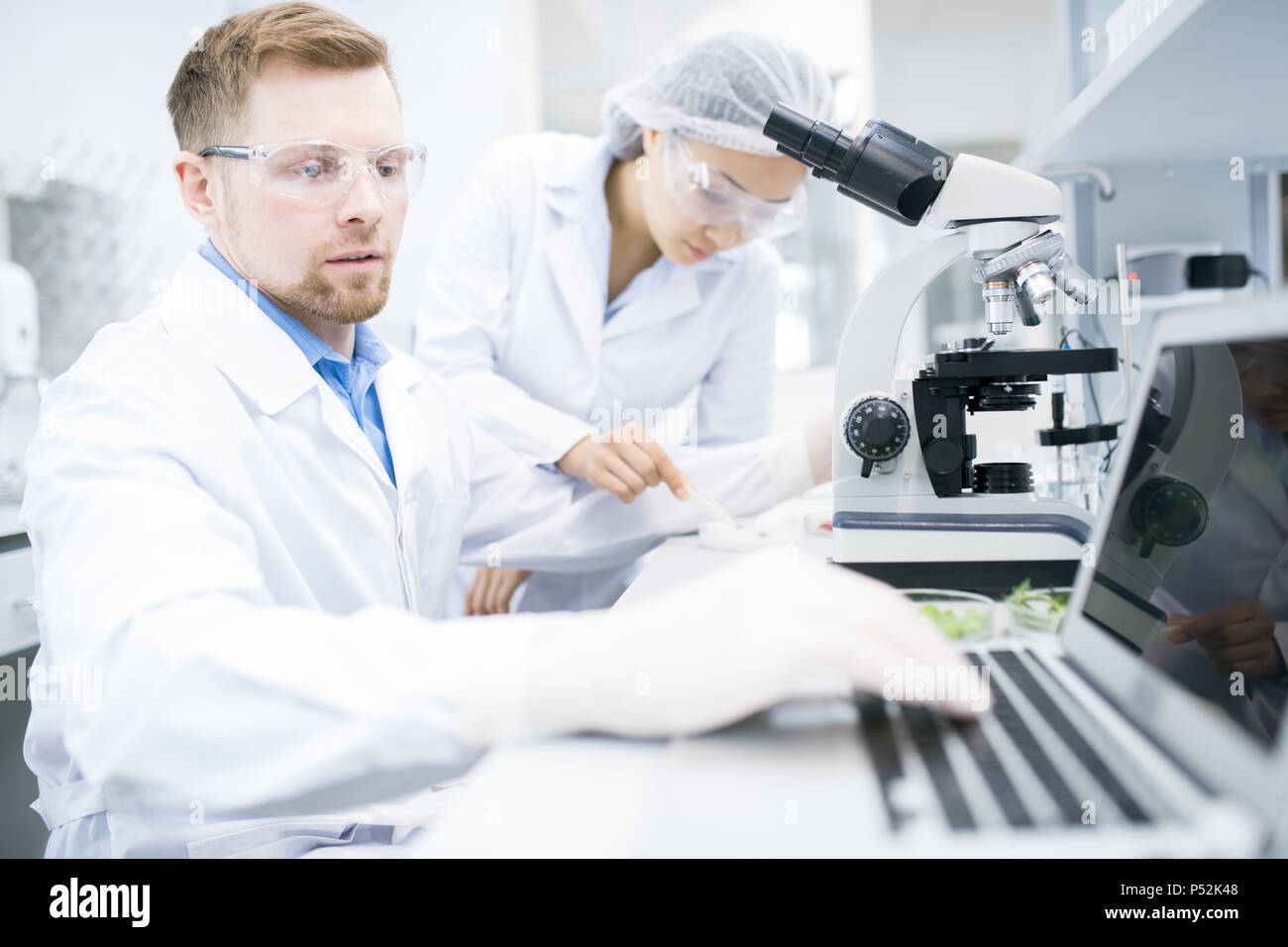 Wissenschaftler schreiben Ergebnisse der Mikroskop Forschung Stockfoto