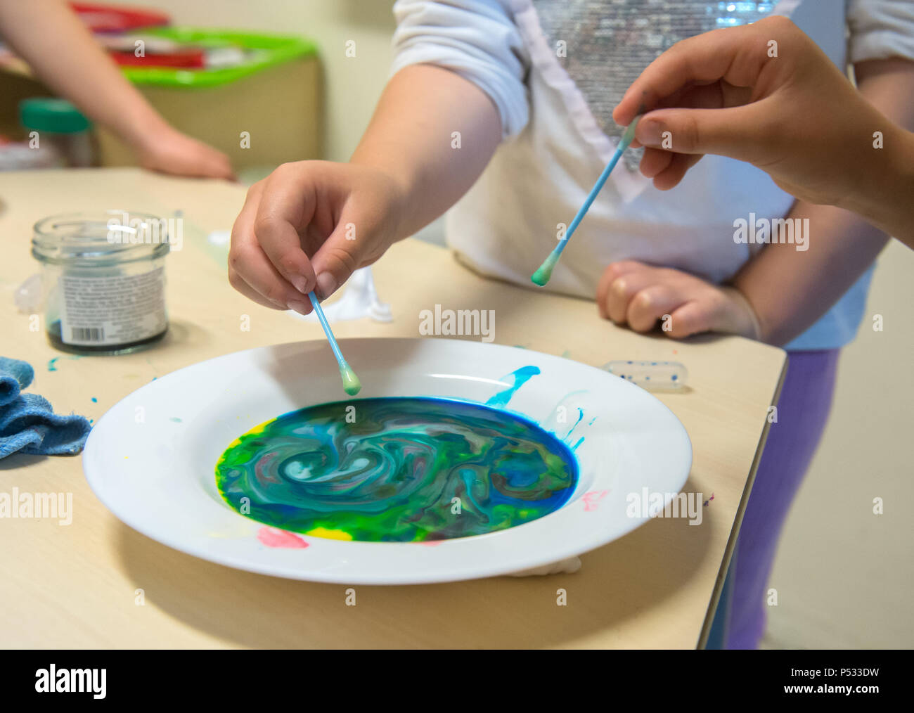 Kinder spielen mit flüssigen Farben in einer Kindertagesstätte Stockfoto