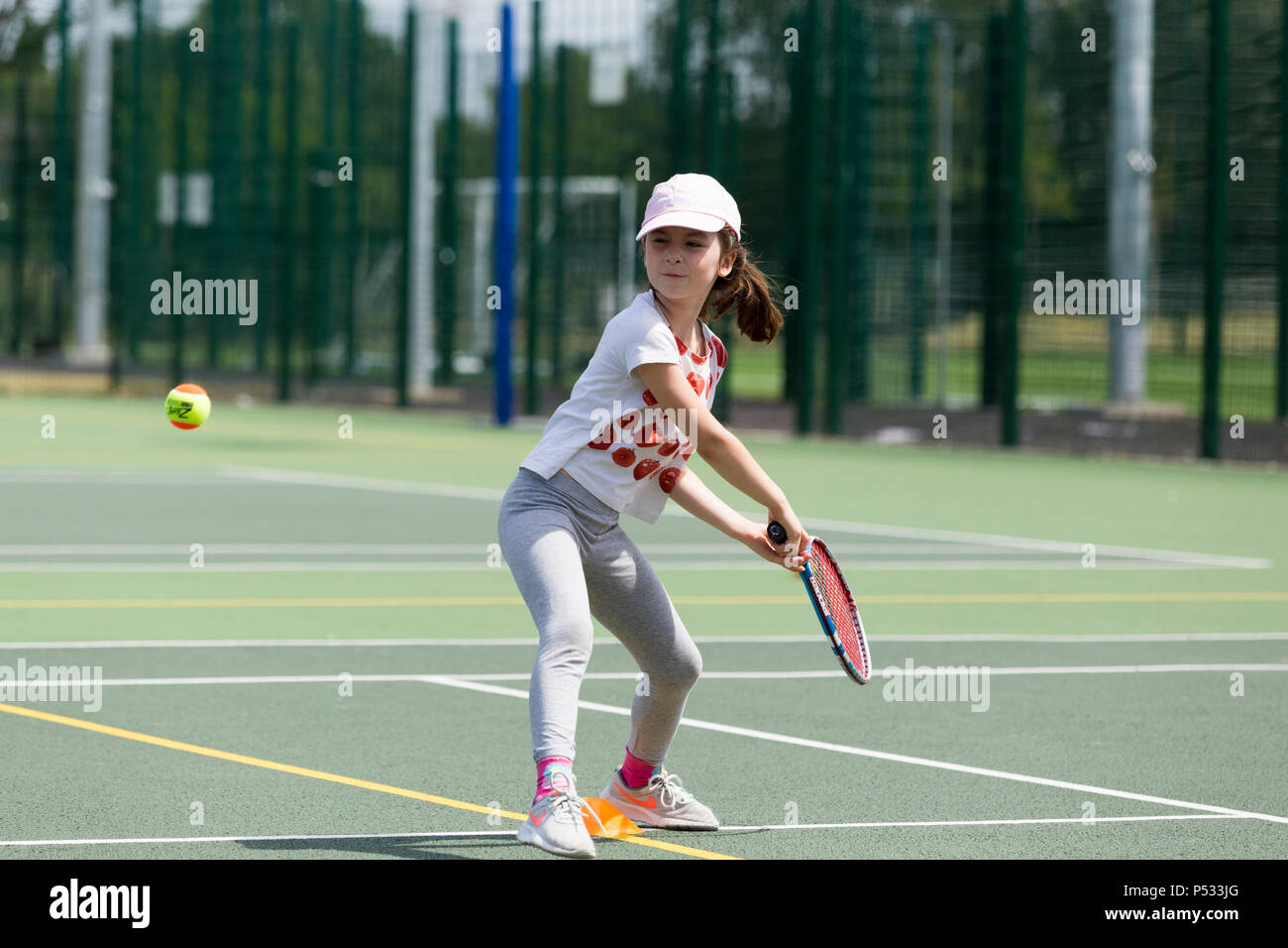 Kinder tennis Coaching/Lektion statt auf einen Tennisplatz mit Kindern/Kindern und professionellen Tennistrainer, im Sommer. UK. (99) Stockfoto