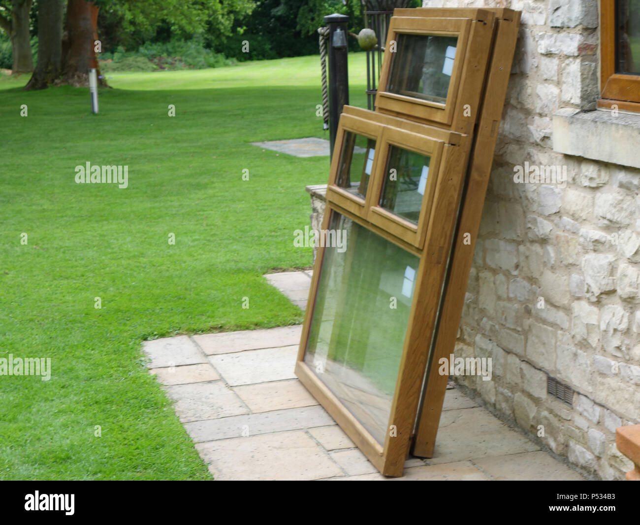 Drei neue doppelt verglaste Massiv eiche Fensterrahmen installiert werden und alte uPVC-Kunststoff Holz Fensterrahmen in einem Heim ersetzen Stockfoto
