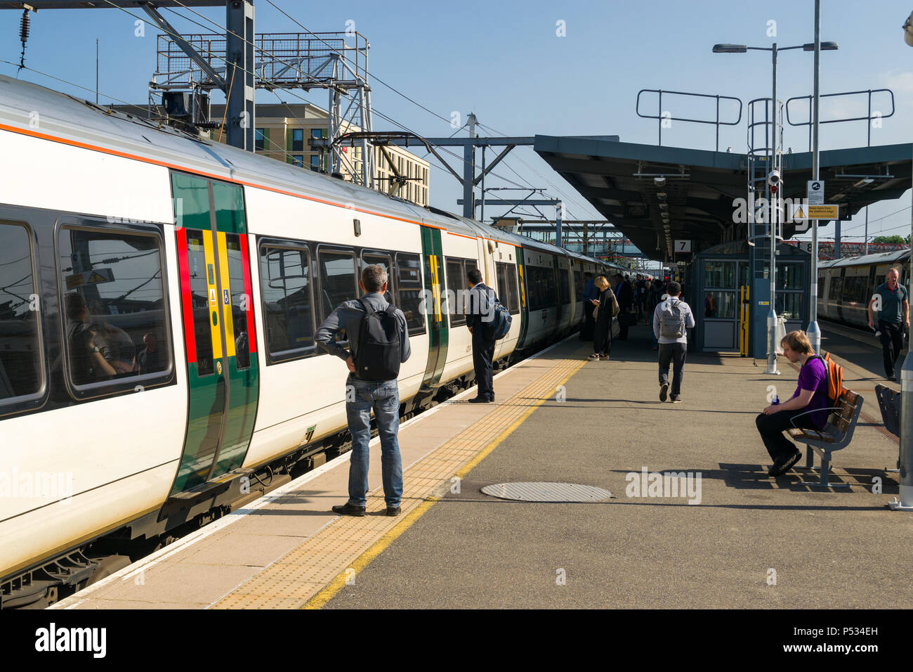 Passagiere warten auf einer Plattform mit dem Zug vom Bahnhof von Cambridge an einem sonnigen Morgen Sommer Stockfoto