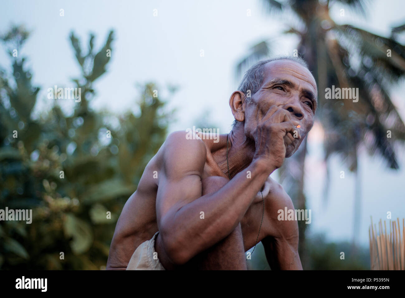 Alter Mann rauchen Zigaretten, die in der Landschaft. Stockfoto