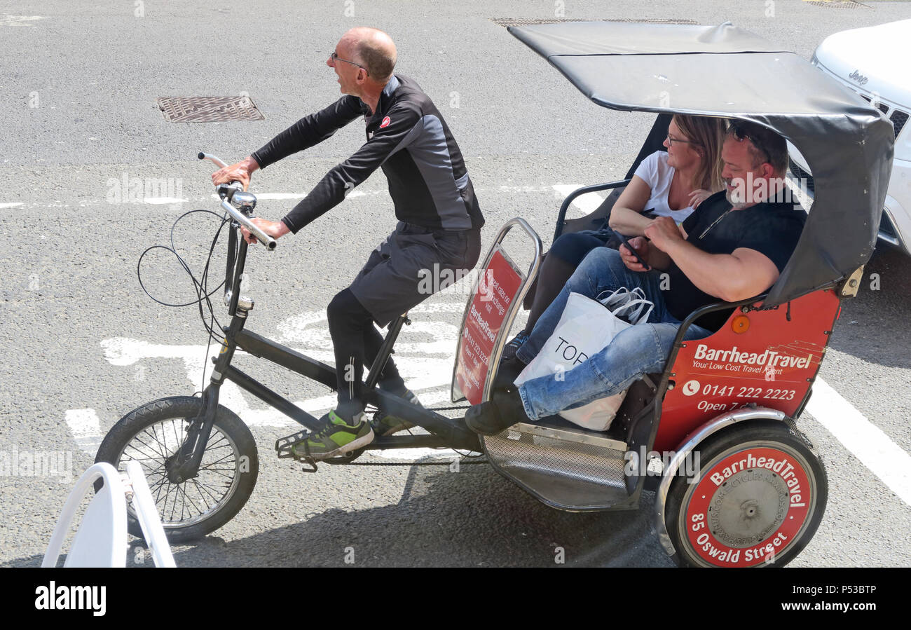 Glasgow Cycle Rickshaw Reiter, mit zwei großen Menschen als Kunden, Schottland, Großbritannien Stockfoto