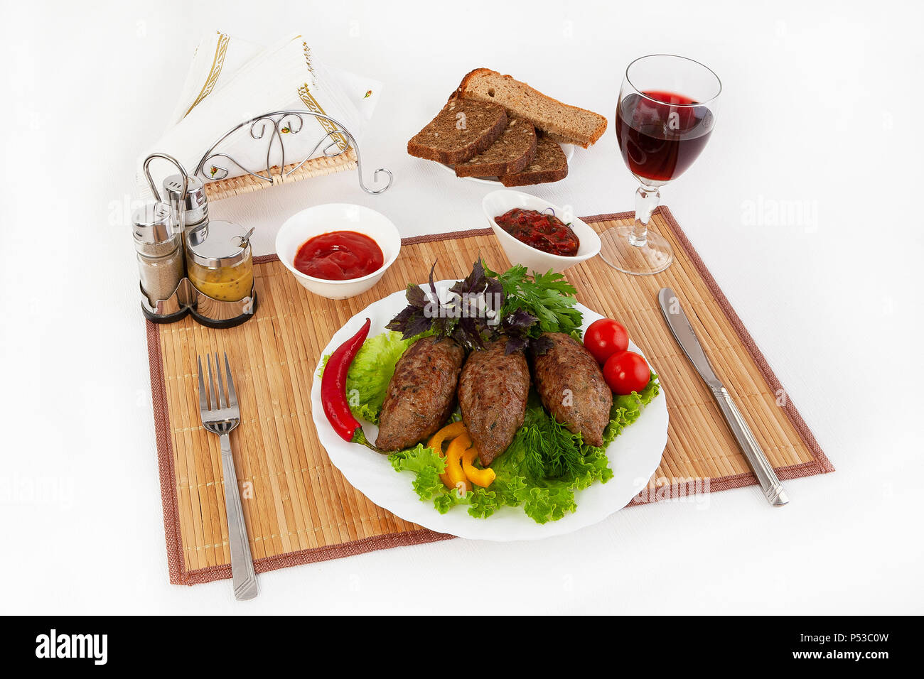 Koteletts mit grünen, Tomaten und Gurken. Mit schwarzen oder weißen Brot und einem Glas Rotwein servieren. Eine perfekte Ergänzung ist eine heiße Soße und Senf. T Stockfoto