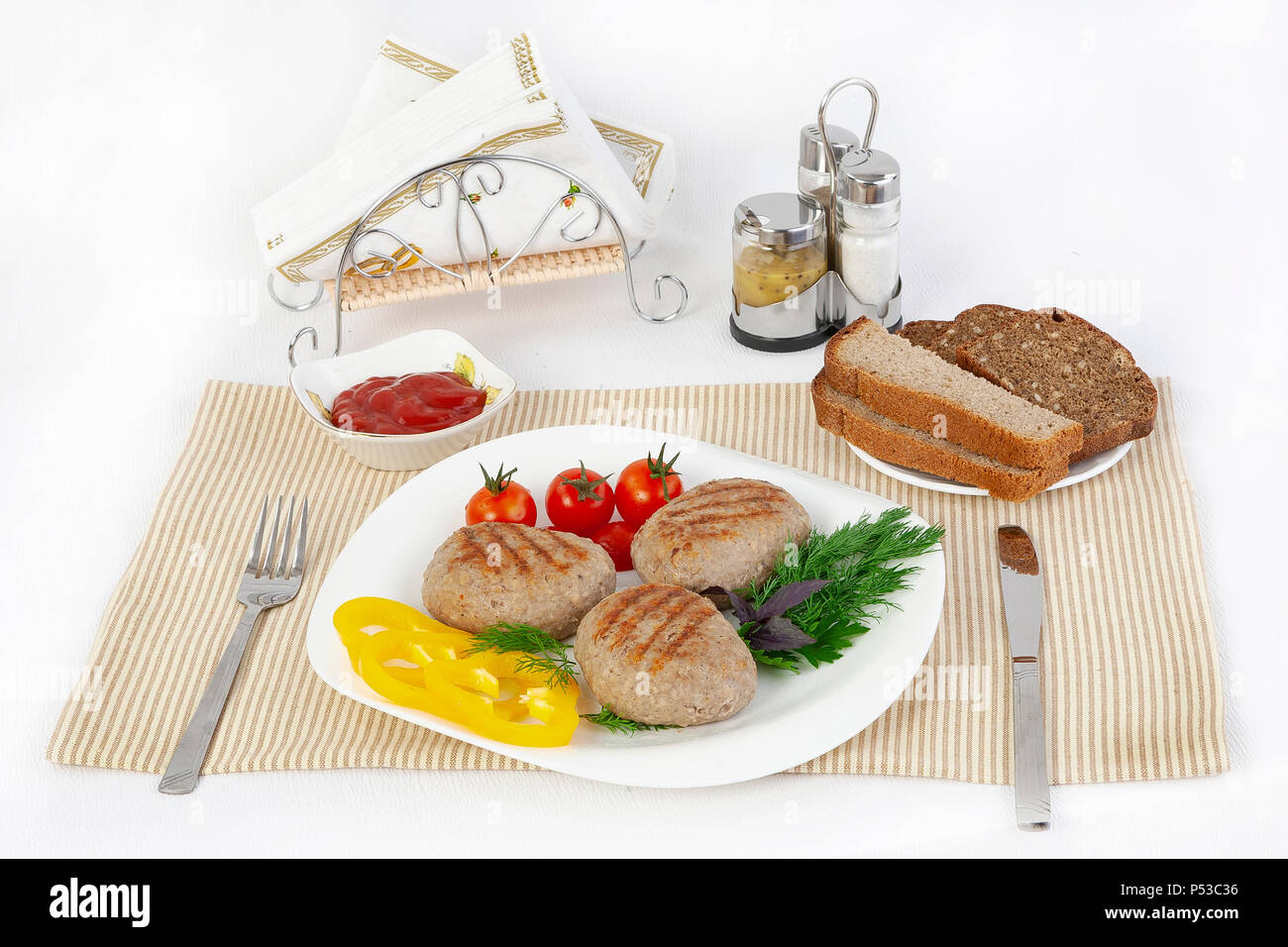 Koteletts mit grünen, Tomaten und Gurken. Mit schwarzen oder weißen Brot und einem Glas Rotwein servieren. Eine perfekte Ergänzung ist eine heiße Soße und Senf. T Stockfoto