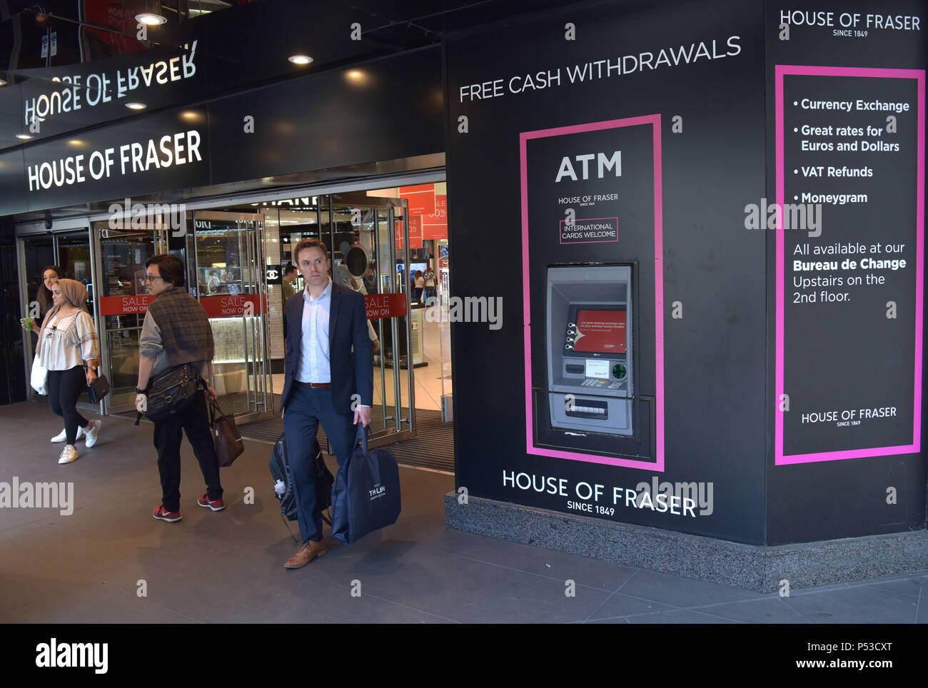 Käufer und Touristen gehen Sie aus dem Department Store House of Fraser auf der Oxford Street in Central London. Eine Werbetafel bietet Geldautomaten wit Stockfoto