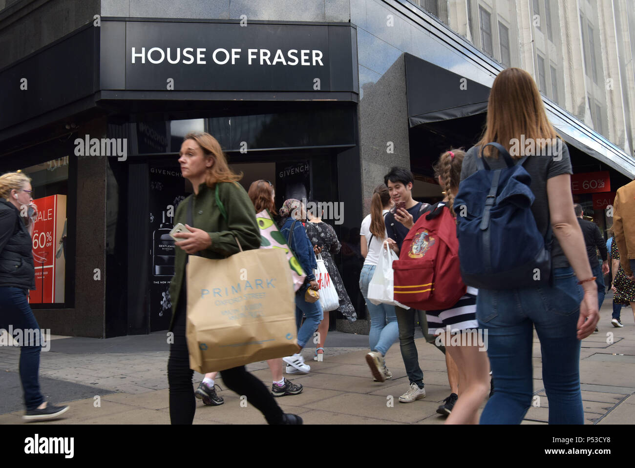 Käufer und Touristen amd eine Frau mit einem Primark Shopping Bag vorbei an den Department Store House of Fraser auf der Oxford Street in Central London. Die c Stockfoto