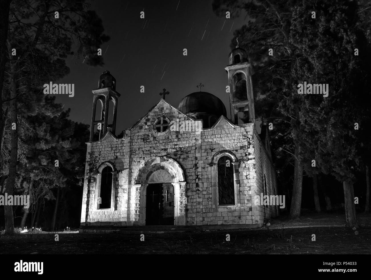 Dramatische alten Kirche bei Nacht in monochromen Farben mit Stern - Wanderwege und Bäume Stockfoto