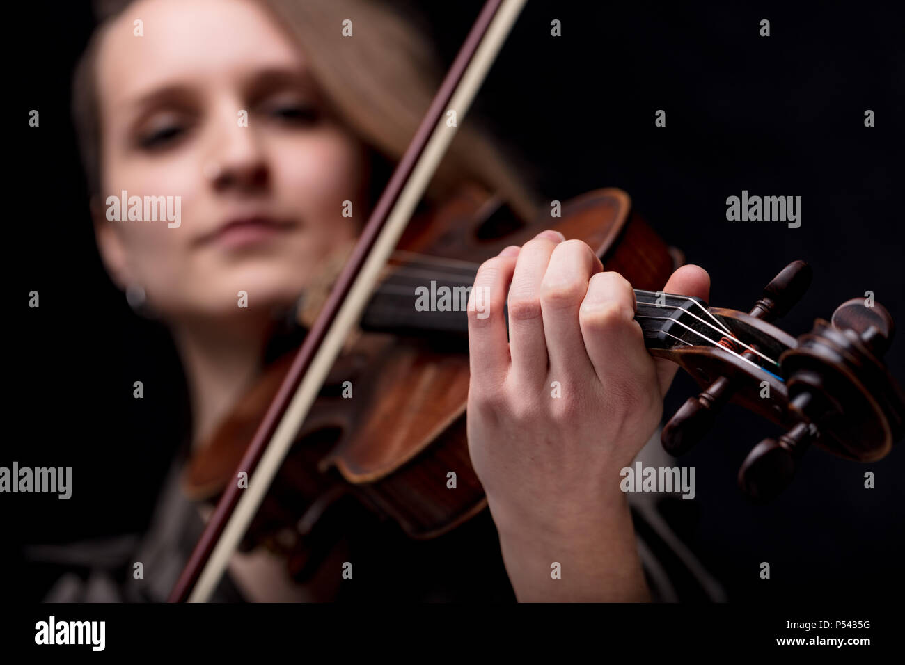 Konzentrieren Sie sich auf die Hand eines barocken Geiger Player auf einem schwarzen Hintergrund, sie ist sehr serios und bestimmt Stockfoto