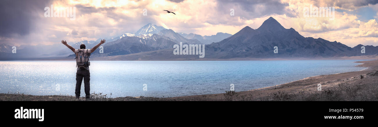 Glückliche Menschen heben die Hände in der Nähe von See. fühlen sich gut, Freiheit und Abenteuer Konzept Stockfoto