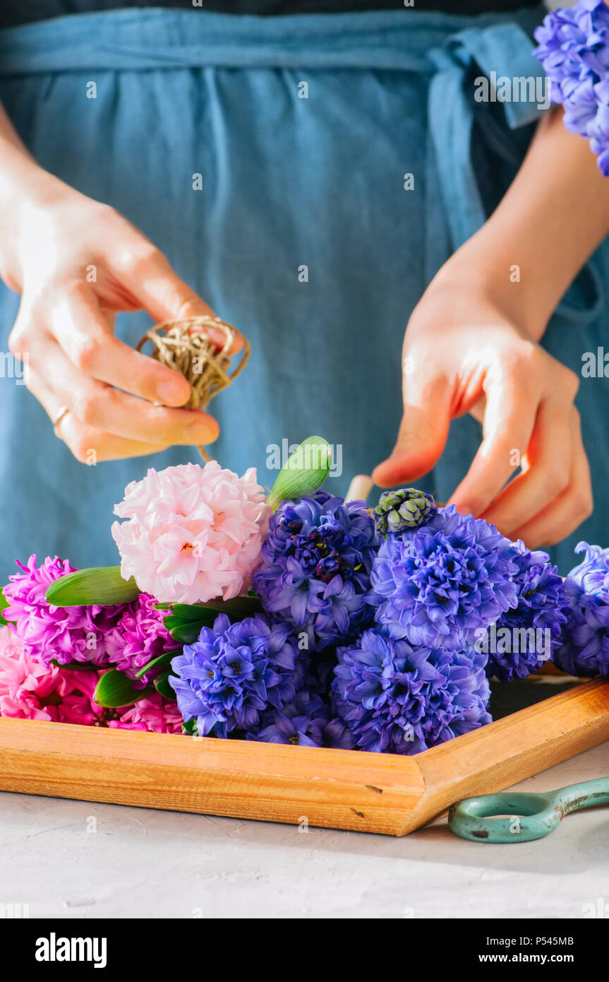Florist Mädchen tieing Blumenstrauß aus Hyazinthen Blumen. Ein Blumengeschäft, ein Geschenk, das Konzept. Stockfoto