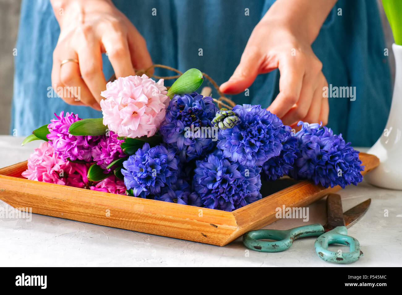 Florist Mädchen tieing Blumenstrauß aus Hyazinthen Blumen. Ein Blumengeschäft, ein Geschenk, das Konzept. Stockfoto