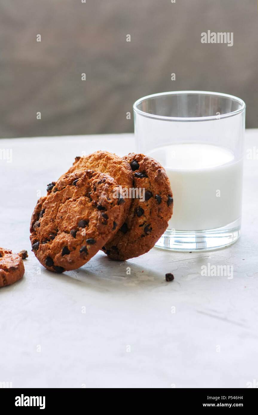 Amerikanische Chocolate Chip Cookies mit Glas Milch auf einen weissen Stein Hintergrund. Top ansehen und kopieren. Stockfoto