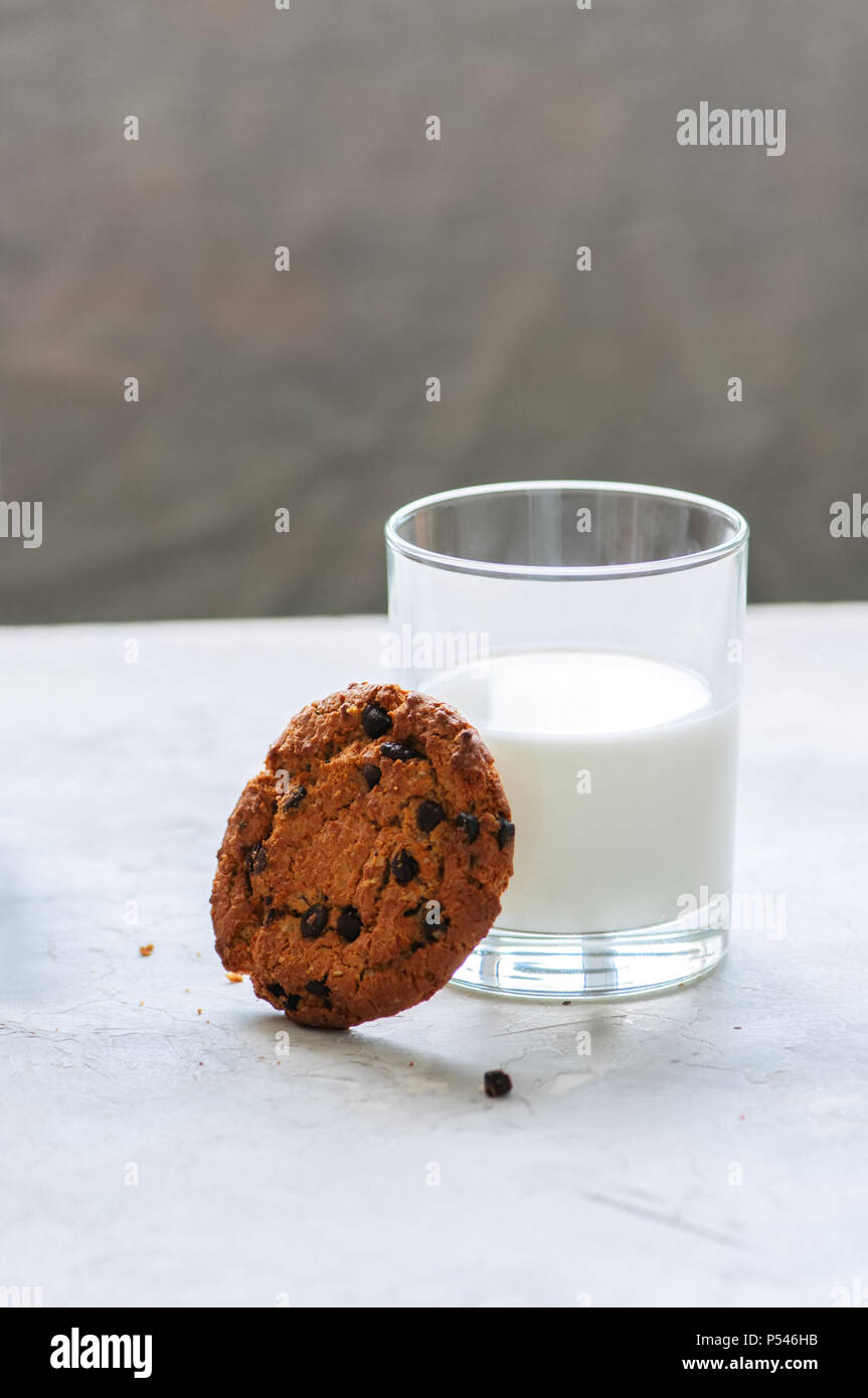 Amerikanische Chocolate Chip Cookies mit Glas Milch auf einen weissen Stein Hintergrund. Top ansehen und kopieren. Stockfoto